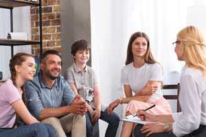 participants in a family integration program talk with a therapist